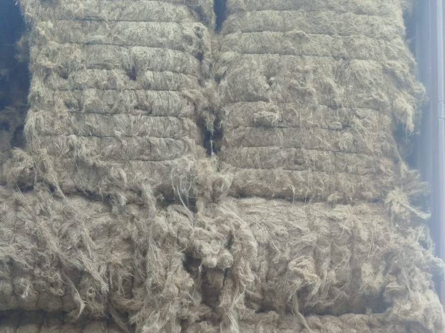 Wire-tied flax bales stacked in a container